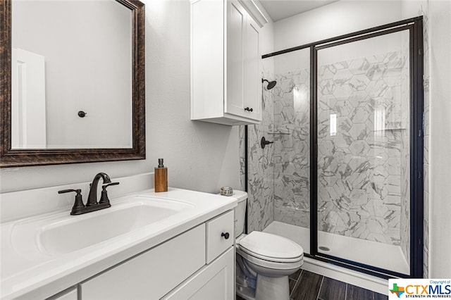 bathroom with walk in shower, vanity, toilet, and hardwood / wood-style flooring