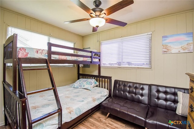 bedroom with wood finished floors and multiple windows