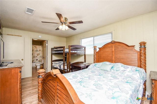 bedroom with a ceiling fan, visible vents, connected bathroom, and light wood-type flooring