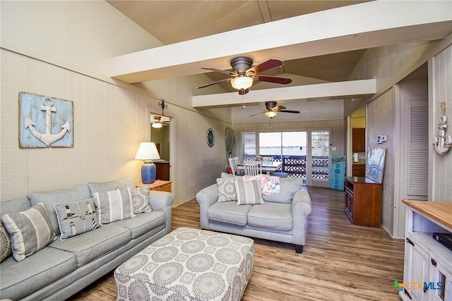 living room featuring beamed ceiling, wood finished floors, and a ceiling fan