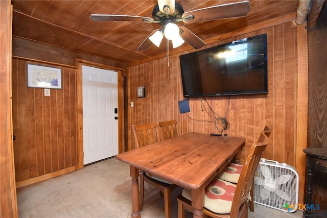 dining room with wooden ceiling, wood walls, and a ceiling fan