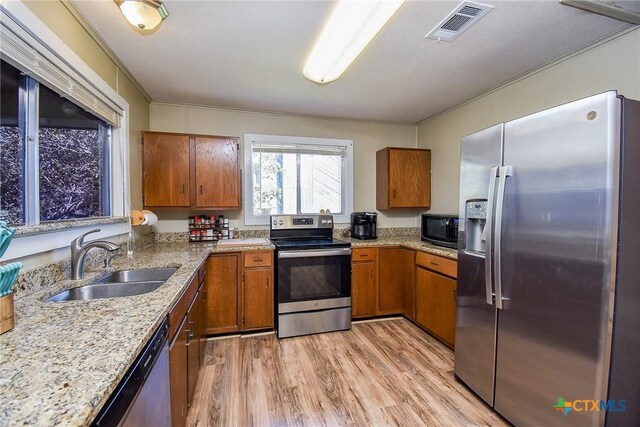 kitchen featuring brown cabinets, visible vents, a sink, and stainless steel appliances