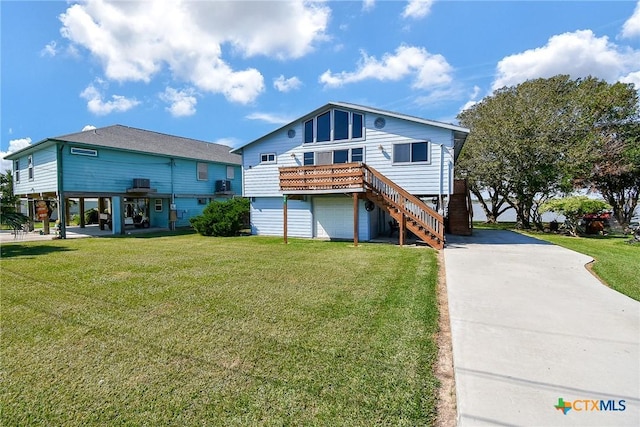 rear view of house featuring a carport, driveway, stairway, and a yard