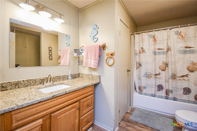 bathroom with wood finished floors, toilet, shower / tub combo, and vanity
