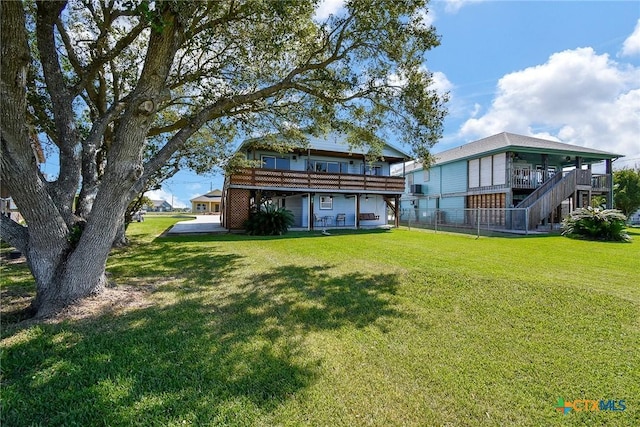 back of house featuring fence, a wooden deck, and a yard