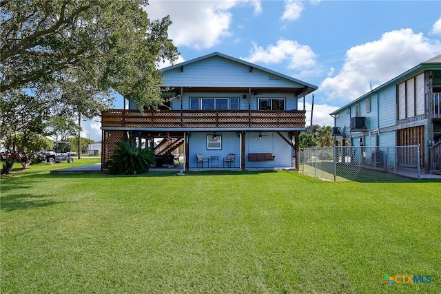 back of property with a lawn, stairs, fence, and a wooden deck