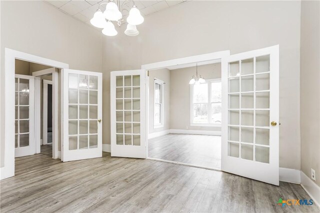 318 Durr St, Marlin, TX 76661 - unfurnished room with a chandelier, french doors, wood finished floors, and a towering ceiling
