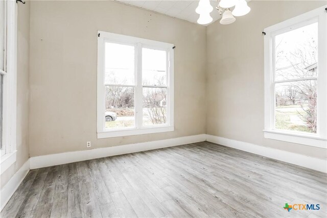 318 Durr St, Marlin, TX 76661 - unfurnished room featuring a chandelier and wood finished floors
