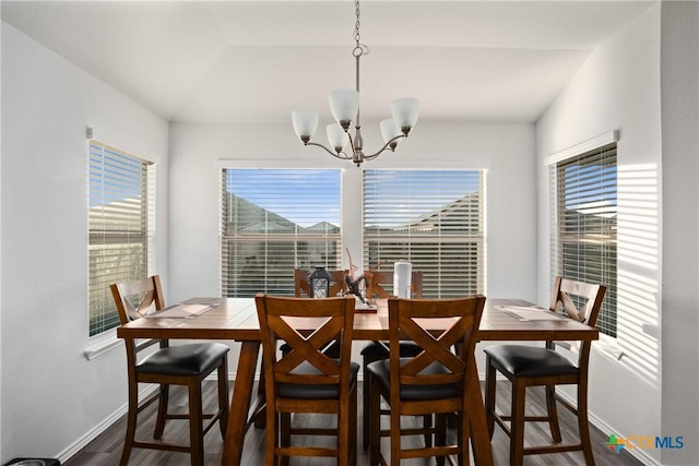 dining area featuring an inviting chandelier, lofted ceiling, and dark hardwood / wood-style floors