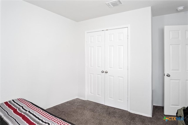 unfurnished bedroom with a closet and dark carpet