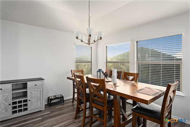 dining space with dark hardwood / wood-style floors and an inviting chandelier