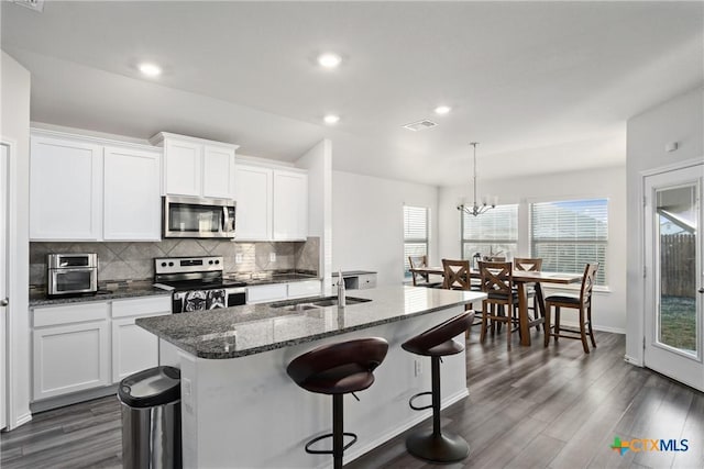 kitchen featuring sink, white cabinets, stainless steel appliances, and a kitchen island with sink