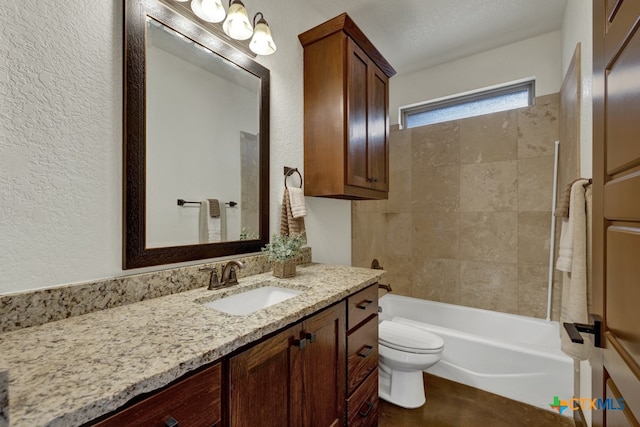 full bathroom with toilet, tiled shower / bath combo, vanity, and a textured ceiling