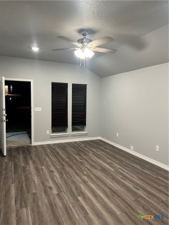 spare room featuring a textured ceiling, vaulted ceiling, ceiling fan, and dark wood-type flooring