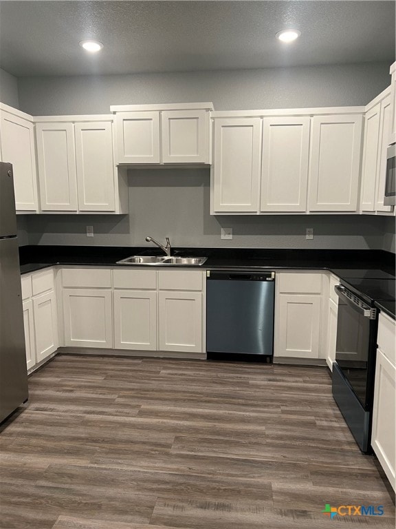 kitchen with sink, appliances with stainless steel finishes, and dark wood-type flooring