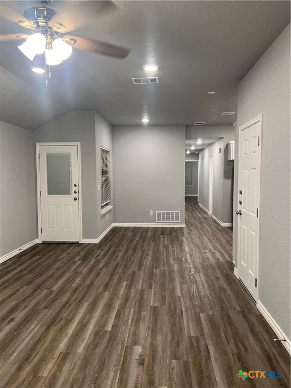 unfurnished living room featuring dark hardwood / wood-style floors, vaulted ceiling, and ceiling fan