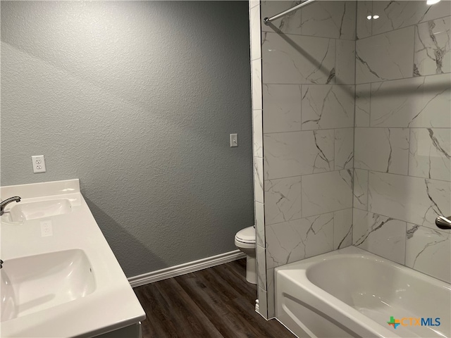 full bathroom featuring vanity, wood-type flooring, tiled shower / bath combo, and toilet