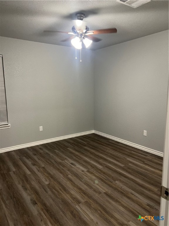 spare room with a textured ceiling, ceiling fan, and dark wood-type flooring