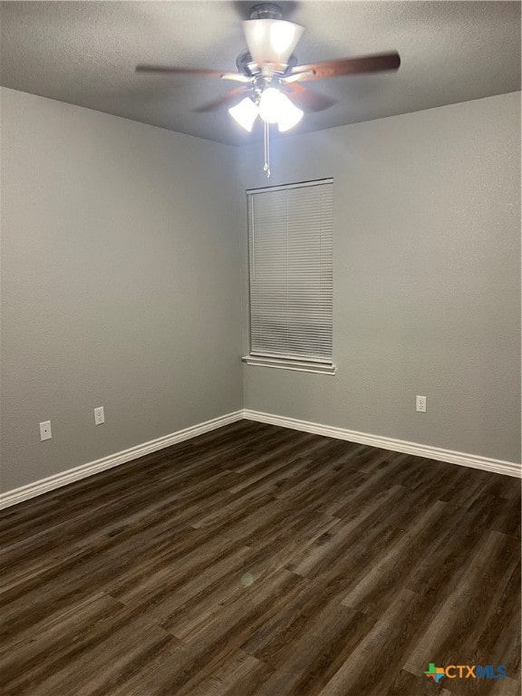 empty room featuring a textured ceiling, ceiling fan, and dark wood-type flooring