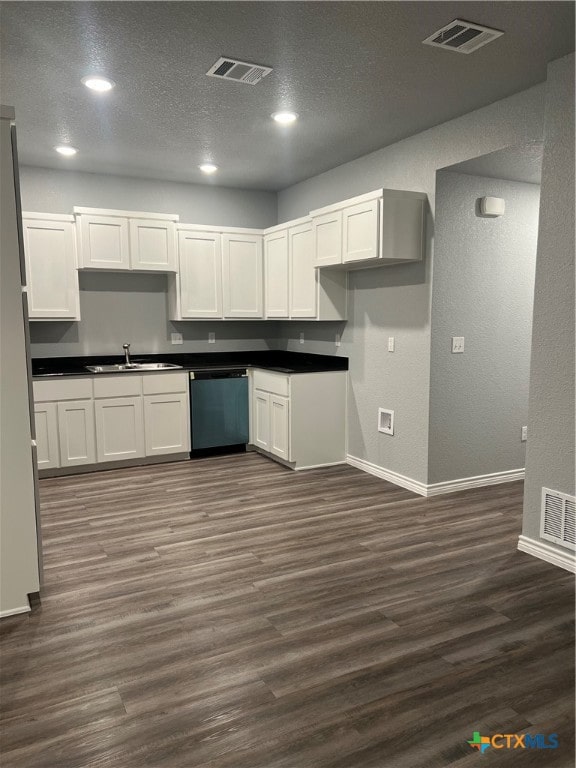 kitchen with dark hardwood / wood-style flooring, white cabinetry, stainless steel dishwasher, and sink