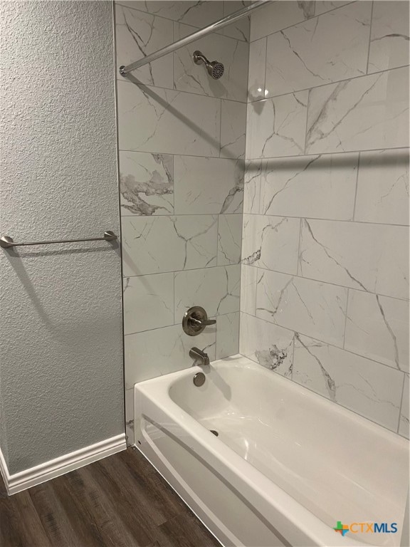 bathroom featuring hardwood / wood-style floors and tiled shower / bath combo