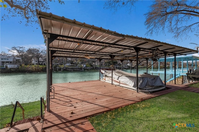 view of dock with a yard and a water view