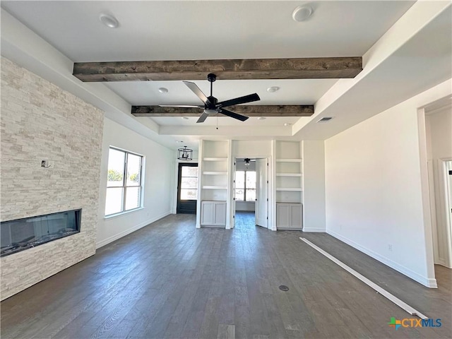 unfurnished living room featuring beam ceiling, ceiling fan, and a fireplace