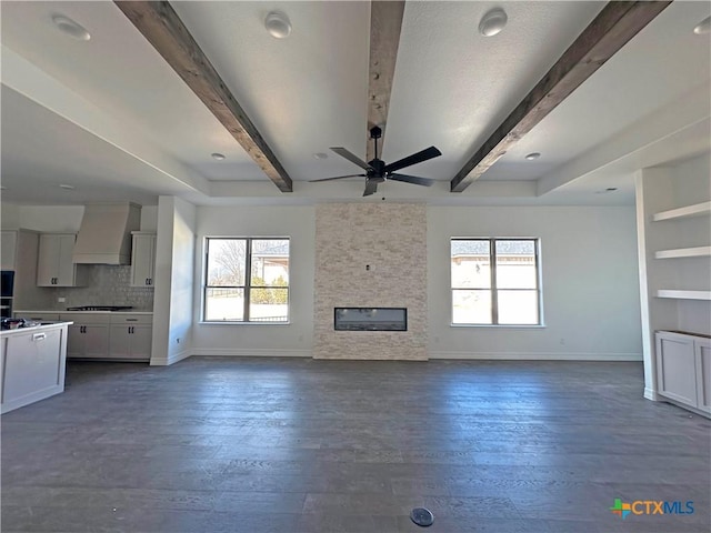 unfurnished bedroom featuring beamed ceiling, ensuite bathroom, and high vaulted ceiling