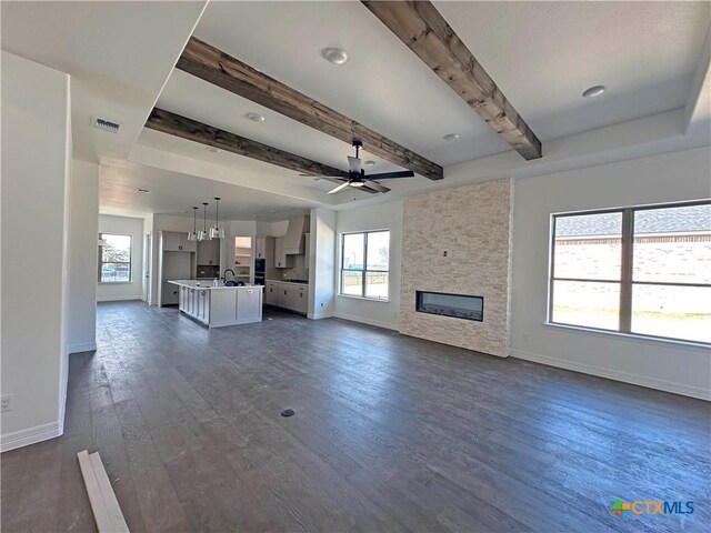 kitchen featuring gray cabinetry, ceiling fan, custom range hood, and an island with sink