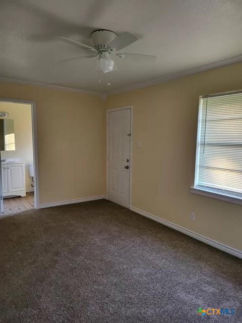 empty room featuring light colored carpet, ceiling fan, and crown molding