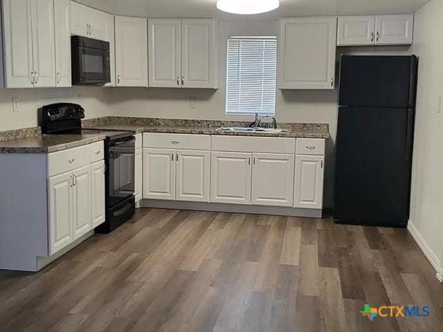 kitchen with sink, dark hardwood / wood-style floors, white cabinetry, and black appliances