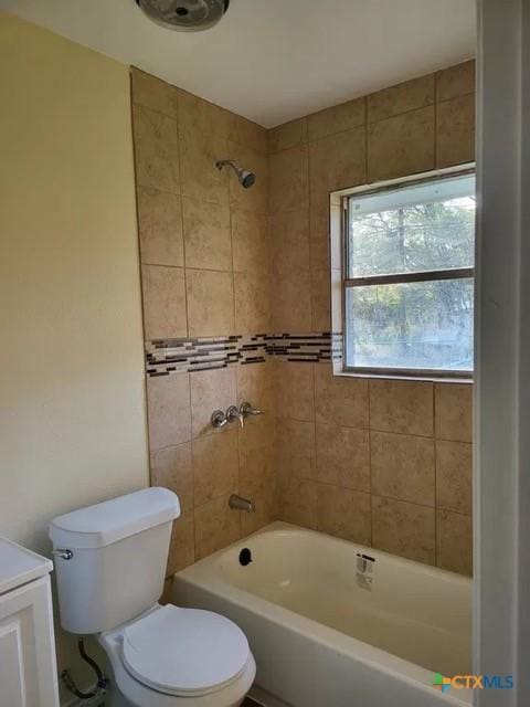 full bathroom with vanity, tiled shower / bath combo, and toilet