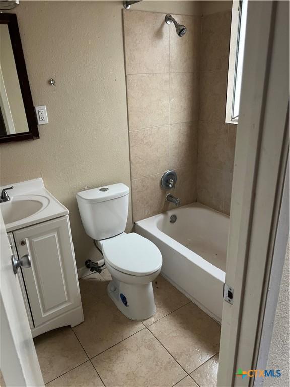 full bathroom with tile patterned floors, toilet, vanity, and tiled shower / bath