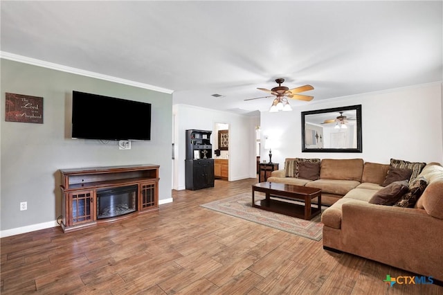 living area featuring wood finished floors, ceiling fan, and crown molding