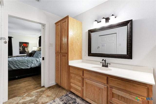 ensuite bathroom with stone finish flooring, ensuite bath, and vanity