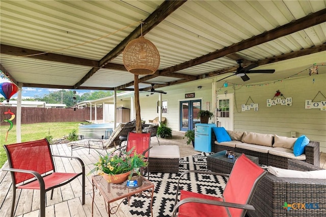view of patio / terrace with french doors, a fenced backyard, a hot tub, ceiling fan, and an outdoor living space