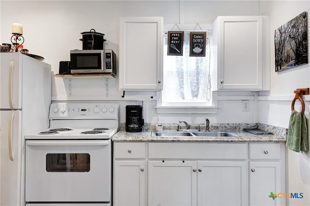 kitchen featuring white cabinets, a sink, and white appliances