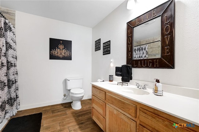 bathroom featuring wood finished floors, vanity, a shower with curtain, baseboards, and toilet