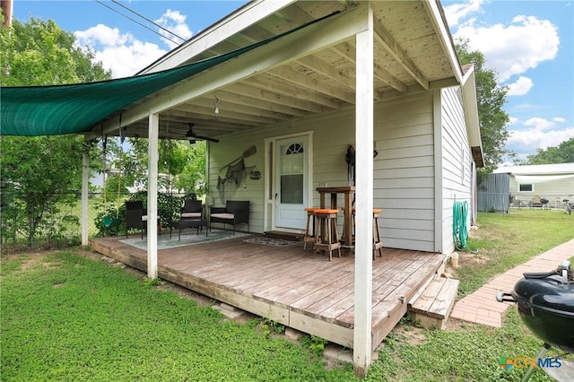 exterior space with fence, ceiling fan, and a yard