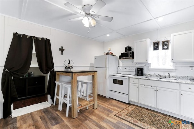 kitchen featuring wood finished floors, a sink, white appliances, ceiling fan, and recessed lighting