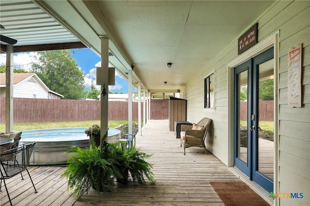 wooden terrace featuring a fenced backyard and a hot tub