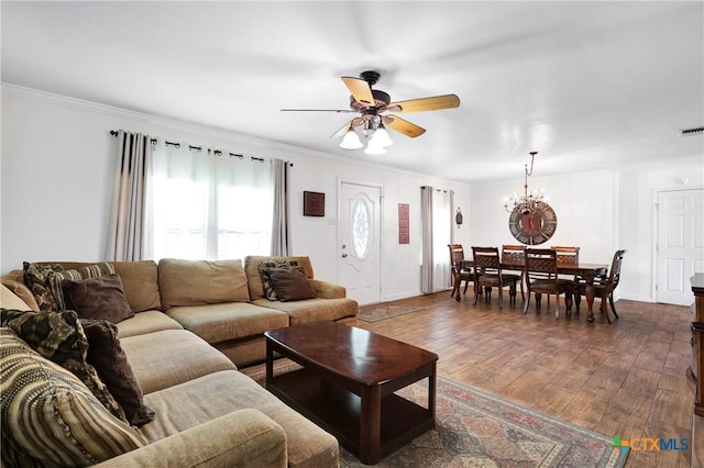 living room featuring visible vents, ornamental molding, dark wood-type flooring, baseboards, and ceiling fan