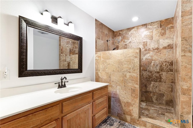 bathroom featuring visible vents, vanity, a walk in shower, and recessed lighting