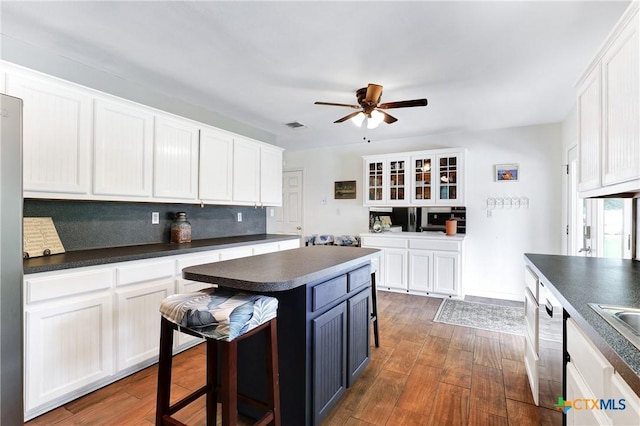 kitchen with dark countertops, white cabinetry, ceiling fan, and dark wood finished floors
