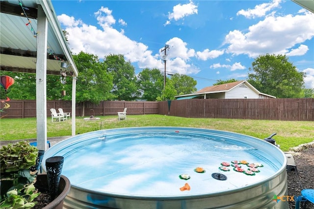 view of swimming pool with a yard and a fenced backyard