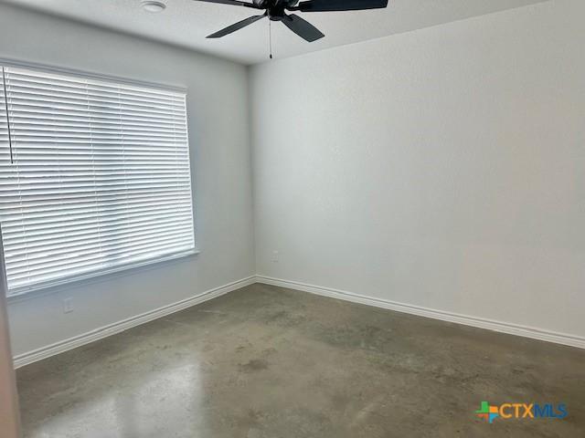 2225 Wooster St, Nolanville, TX 76559 - empty room featuring concrete flooring, ceiling fan, and plenty of natural light