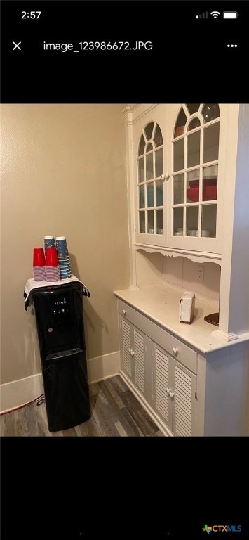 bar featuring white cabinetry and dark wood-type flooring