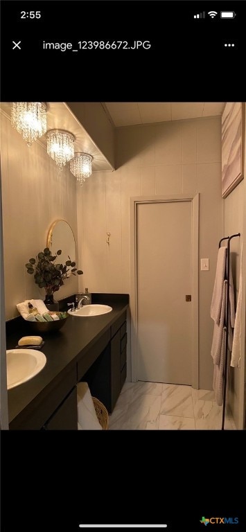 bathroom with a chandelier and vanity