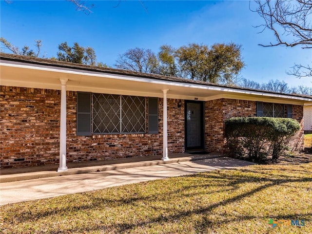 exterior space featuring a front lawn and brick siding