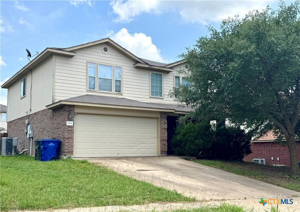 2204 Vernice Dr, Copperas Cove, TX 76522 - view of front facade with brick siding, driveway, a garage, and a front lawn